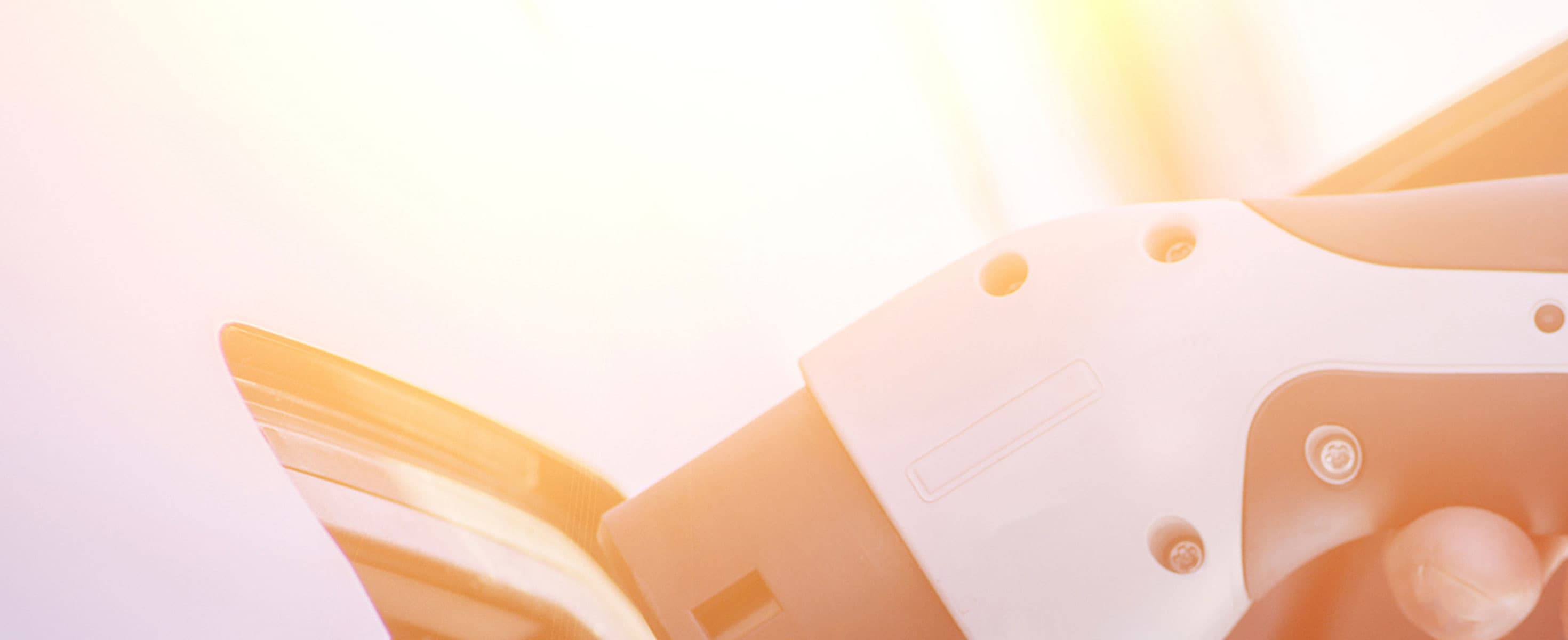 Ein E-Autoladekabel wird anngeschloßen. Im Hintergrund blendet die Sonne